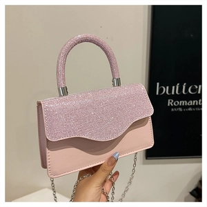 Detail of pink crystal encrusted leather handbag with silver chain and wavy flap design