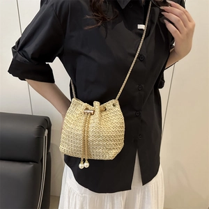 Modern straw bucket bag with gold chain and pearl drawstring for summer styling