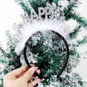 Detail of Happy New Year headband with white feathers and silver glitter lettering