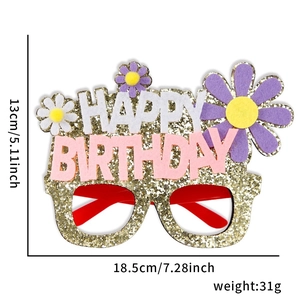 Close-up of birthday party glasses with gold glitter frames and daisy felt decorations