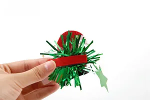 Close-up of a Christmas hat hair clip with red felt, green sequins and white mesh