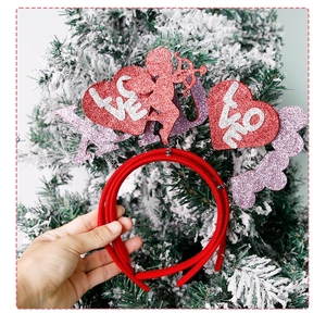 Detail of red Valentine's headband with glitter hearts and LOVE text on snowy background