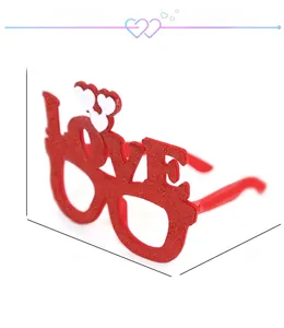 Red glitter LOVE shaped party glasses with white heart accents for festive photography