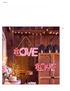 Detail of wooden Valentine's LOVE ornaments with red bows and rustic heart cutouts