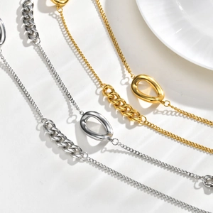 Détail des chaînes à mailles gourmettes dorées et argentées avec pendentifs goutte d'eau