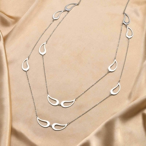 Détail de breloques en forme de larme sur collier long multicouche en soie dorée