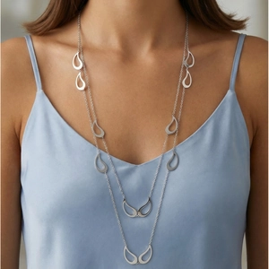 Gros plan d'un collier double rang en acier inoxydable argenté avec pendentifs gouttes