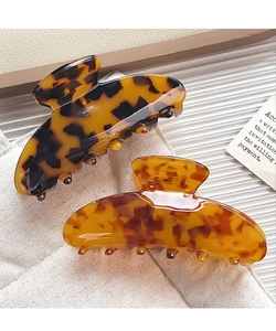 Detailed view of large acetate hair claws in dark tortoiseshell and amber colors