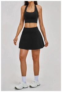 Detailed view of women's black backless long sleeve yoga top and athletic tennis skirt