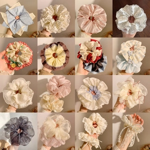 Collage of diverse scrunchies in silk, lace, and floral fabrics with pearl details