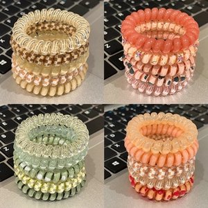 Detail view of colorful spiral telephone wire hair ties in floral and checkered patterns