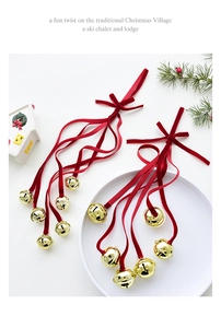 Christmas village bells set with red ribbons and gold star cutout charms on table