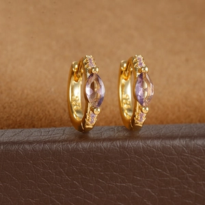 Macro shot of gold S925 earrings with purple stones and a 925 authenticity hallmark