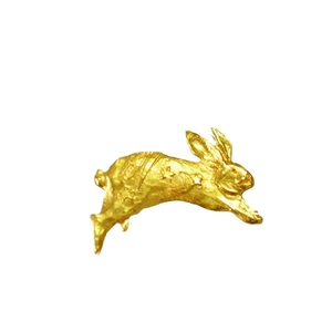 Vintage 3D sculpted gold bunny brooch with celestial moon and star pattern on white background