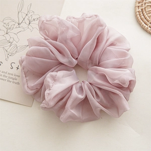 Detail of pink chiffon scrunchie showing pleated texture and light soft fabric