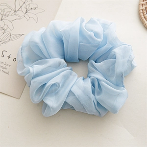 Detailed view of light blue chiffon scrunchie with layered pleats and airy texture