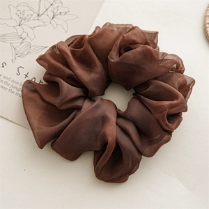 Detail of coffee brown oversized chiffon scrunchie with layered translucent fabric texture