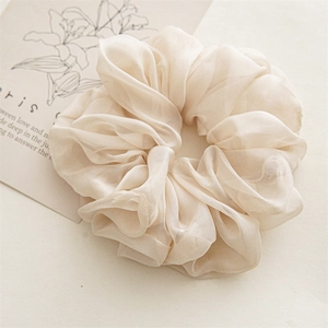 Close-up of large cream chiffon scrunchie showing delicate sheer texture and soft pleats