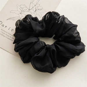 Close-up of a large black ruffled chiffon scrunchie with layered translucent fabric