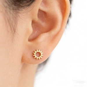 Minimalist 925 sterling silver sunflower stud earring with golden finish worn by a model