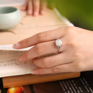 Detail shot of a square white jade S925 silver ring with elegant hollowed out band accents