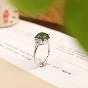 Macro shot of silver ring featuring square green jasper and hollowed flower detail