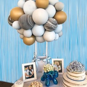 Blue fringe curtain backdrop with pastel balloon arch and baby shower party decorations