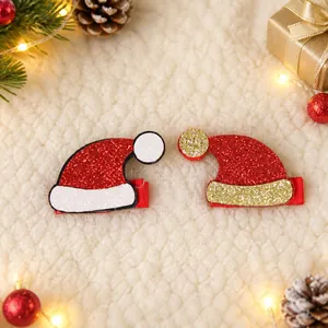 Dettaglio di fermagli per capelli a cappello di Babbo Natale glitterati in rosso e oro