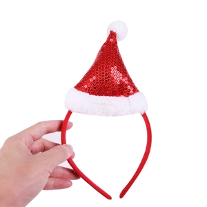 Detail of red sequined Christmas hat headband with plush white trim and fluffy pompom