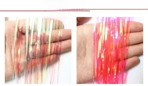 Dettaglio di tende a frange iridescenti bianche e rosso rosa con lucentezza olografica