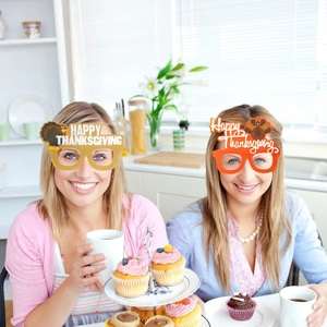 Detail of two fun Thanksgiving party glasses featuring turkey shapes and festive greetings
