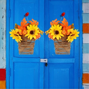 Autumn hanging flower basket with sunflowers, maple leaves and pumpkins on a blue door