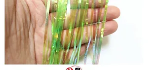 Dettaglio macro di frange in lamina verde laser cangiante con effetto arcobaleno metallico