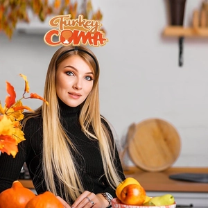 Lustiger Thanksgiving-Haarreif mit Turkey COMA Schriftzug vor herbstlicher Deko