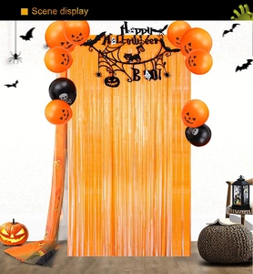 Halloween party set with orange fringe curtain, pumpkin balloons and BOO banner