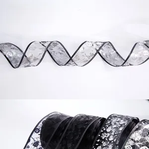 Detail of Halloween sheer mesh ribbon with silver skull, pumpkin, and spider web prints
