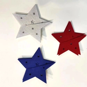 Close-up of red white and blue felt star decorations with hollow-out patterns