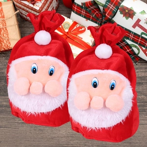 Detail of red velvet Santa Claus gift bags with plush pompoms and white faux beards