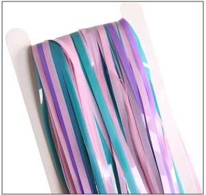 Close-up of pink, blue, and purple foil fringe curtains wrapped on white cardboards