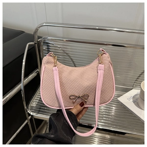 Detail of pink corduroy moon bag with a golden bow charm and high-quality metal buckles