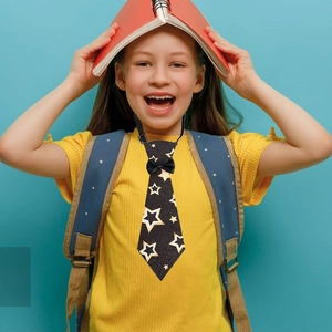 Detail of pre-tied graduation tie featuring gold star patterns and adjustable elastic neck strap