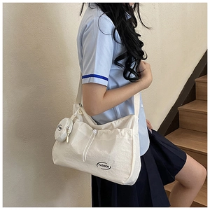 Detail der cremeweißen Canvas-Tasche mit Mini-Geldbeutel und schwarzem FASHION-Logo