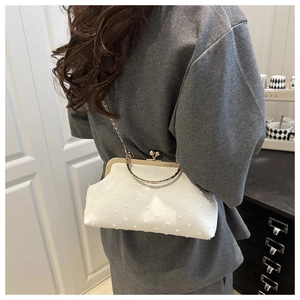 Detailed close-up of white vintage-style frame bag with textured fabric and gold hardware