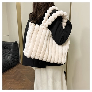 Detailed macro view of cream plush tote bag featuring soft fur textures and striped pleats