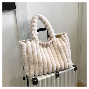 Detailed texture of off-white plush tote bag with vertical stripes and bubble handle
