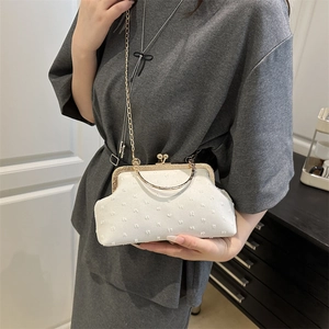 Elegant white polka dot textured kiss-lock bag with gold handle and chain strap
