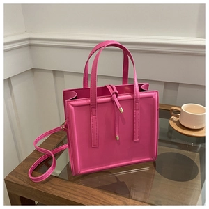 Detail of hot pink tote bag with vertical straps and gold metallic drawstring accents