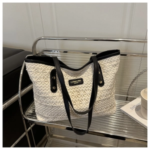 Detail of white crochet tote bag with geometric floral patterns and black leather straps