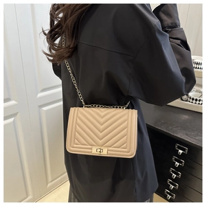 Side view of beige quilted faux leather crossbody bag with golden chain and metal lock