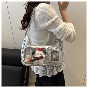 Detail of silver metallic tote bag with clear display pocket and plush toy accessory